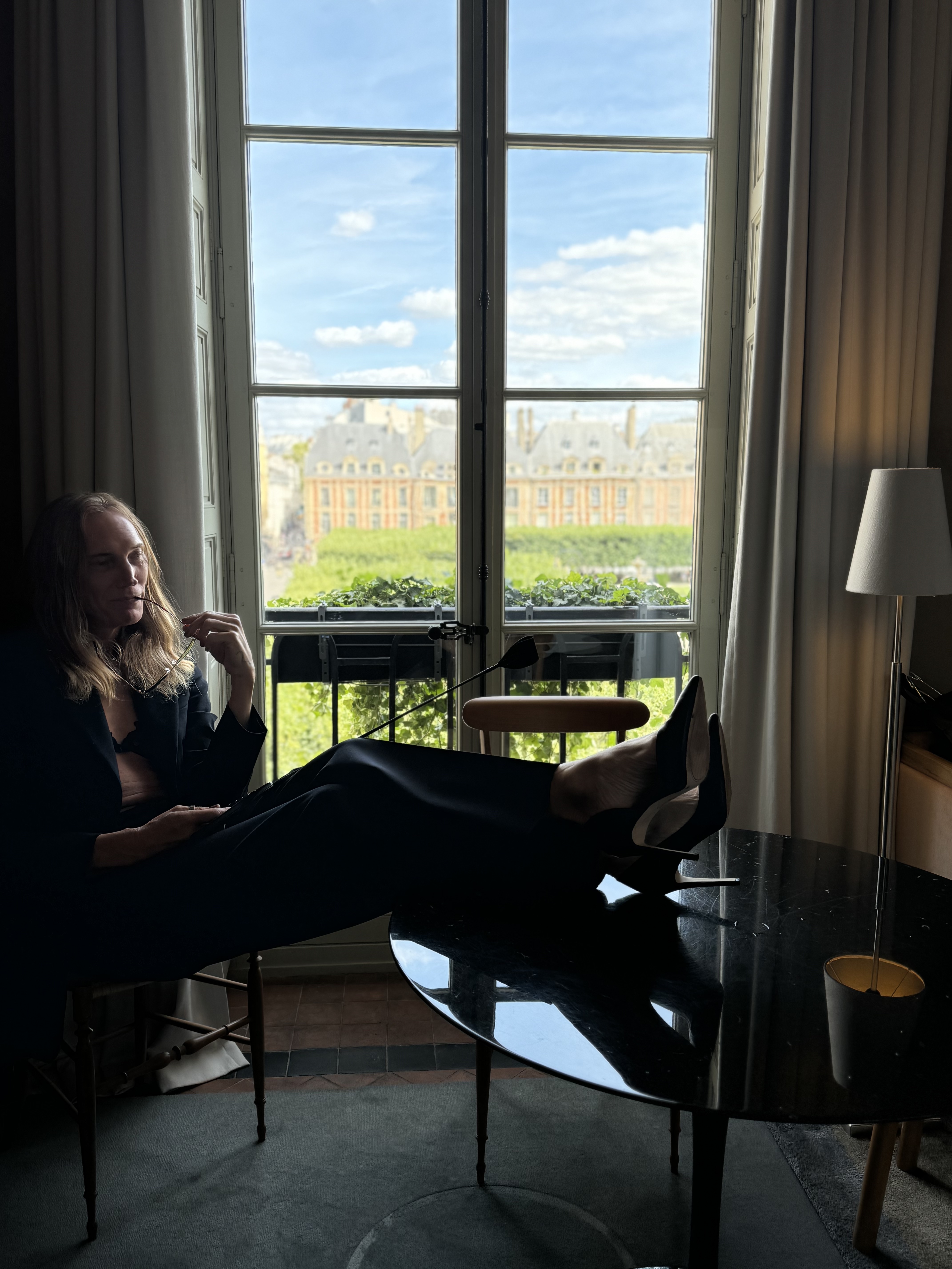 Mx Valentina seated in a private interior, visible by choice while clients remain invisible by design