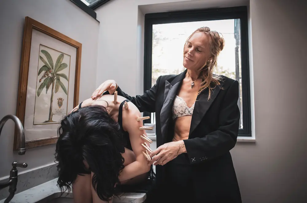 Mx Valentina, a London-based somatic practitioner and dominatrix, providing grounded care and physical structure during an elite power exchange session.